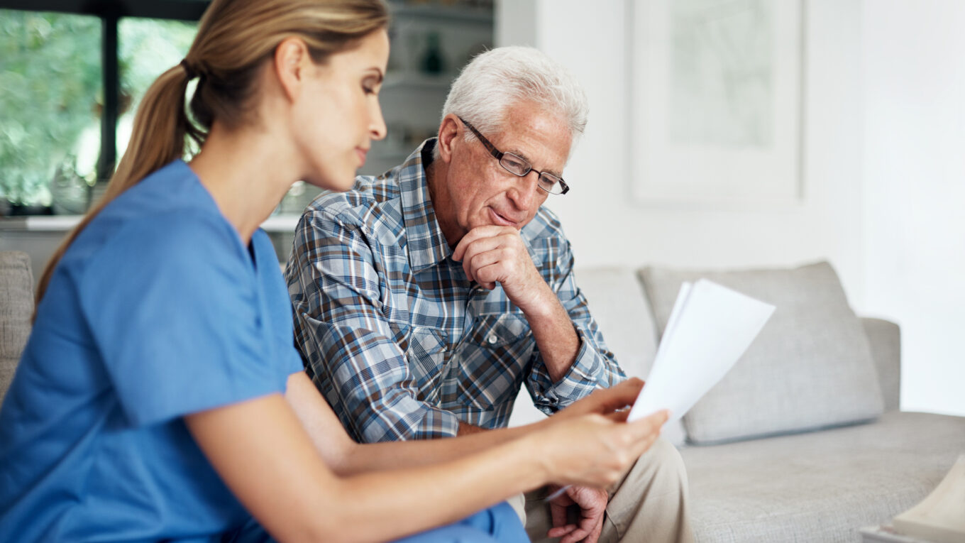 Healthcare professional discussing paperwork with patient
