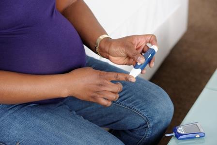 Women's metabolic health Woman using a blood sugar meter to prick her finger