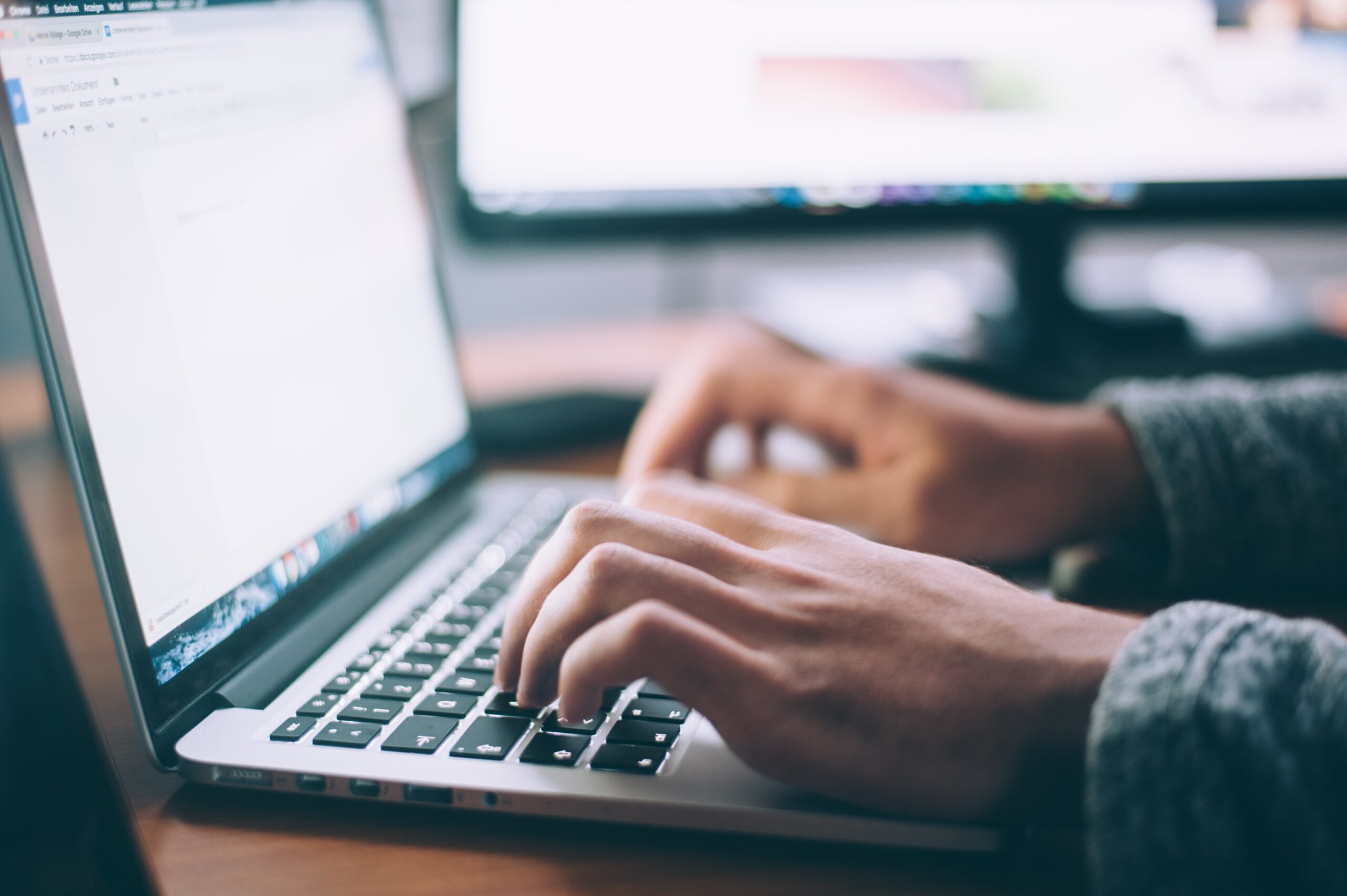 Hands of a man typing on a laptop