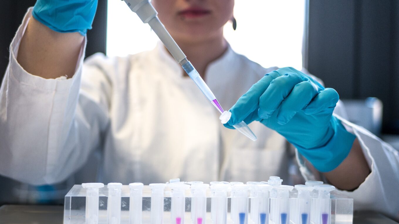 Researcher using pipette in a lab