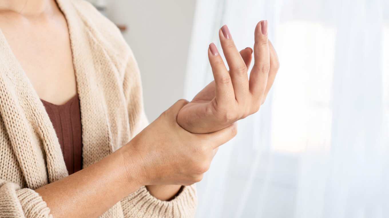Woman holding painful wrist with arthritis