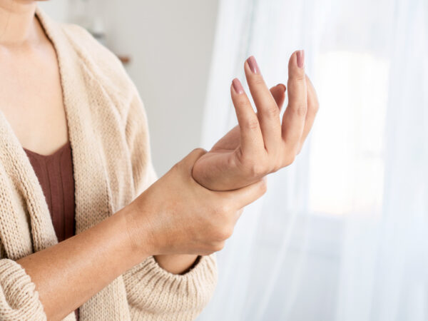 Woman holding painful wrist with arthritis