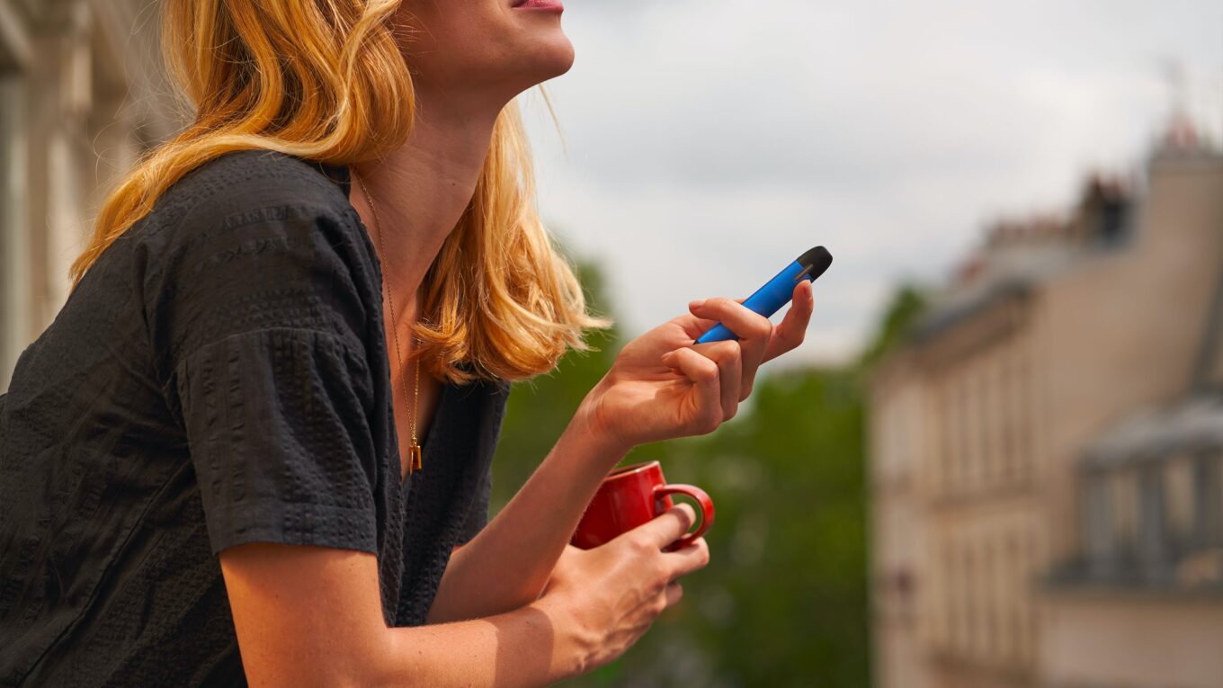 Woman vaping on a balcony
