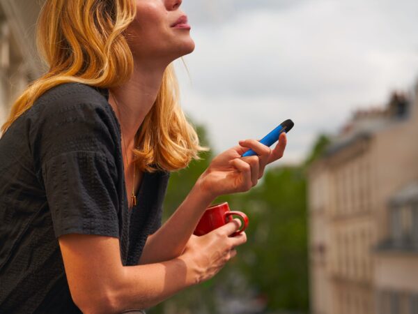 Woman vaping on a balcony