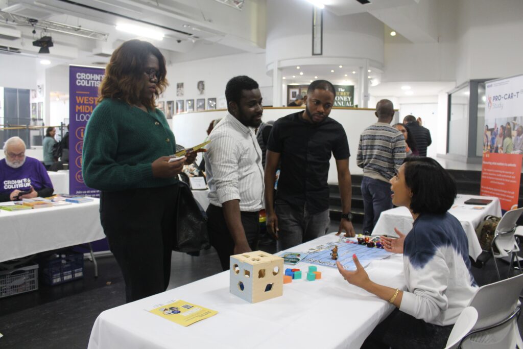IMG_2187 Three attendees engaging at equality stand at community event