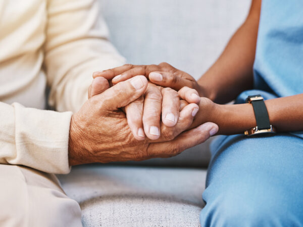 Nurse holding hands of elderly patient