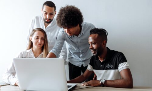 A diverse group of researchers looking at a laptop