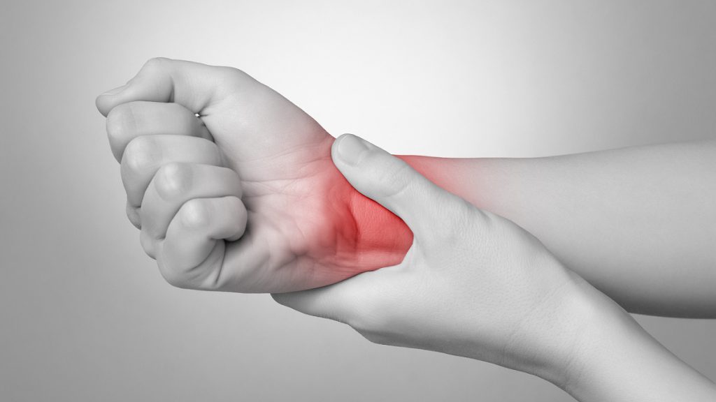 Person holding their painful wrist