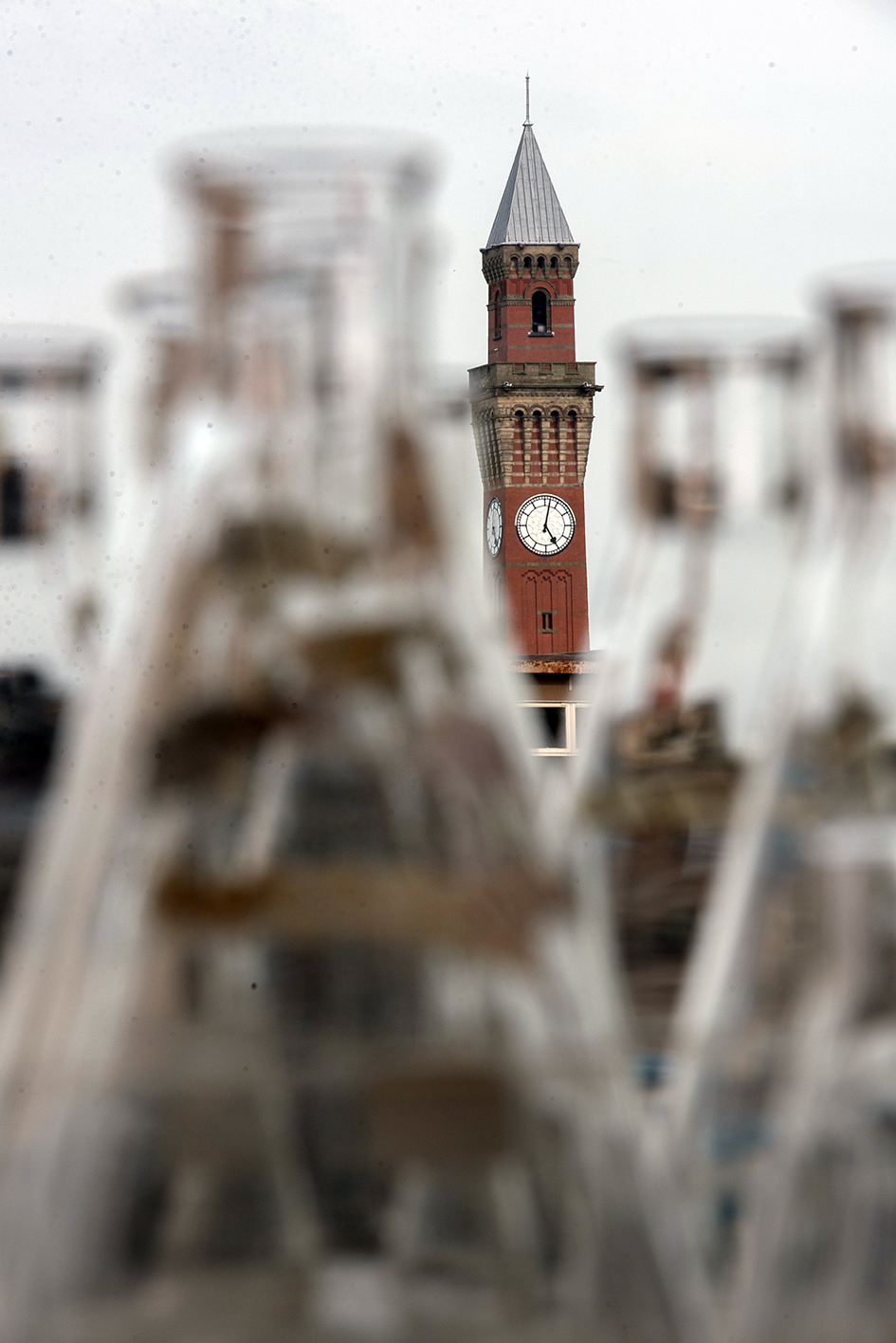 homepage-research Birmingham university's Old Joe clock tower seen through lab flasks
